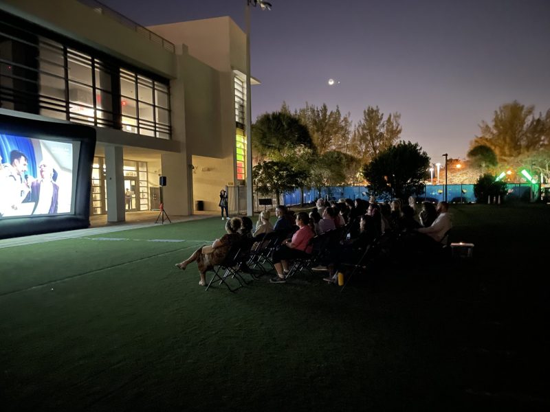 Crowd watching screen outdoors.